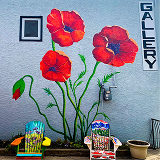 Big red poppies with chairs in courtyard.