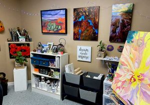 Dawn's studio with paintings on wall and easel.